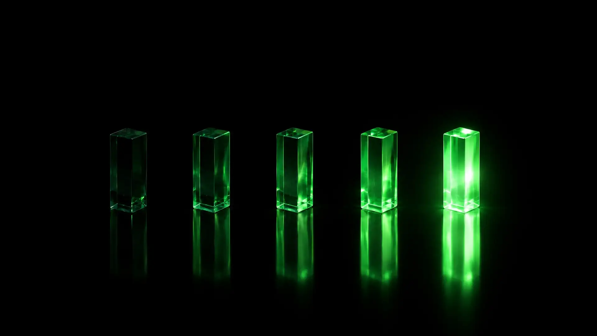 Imagem abstrata em fundo escuro: cinco prismas de vidro verde em fila, cada um mais aceso que o anterior, refletidos no chão, sem texto.